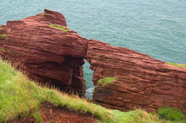 Skalní okno Needle's eye na útesech Seaton Cliffs severně od města Arbroath